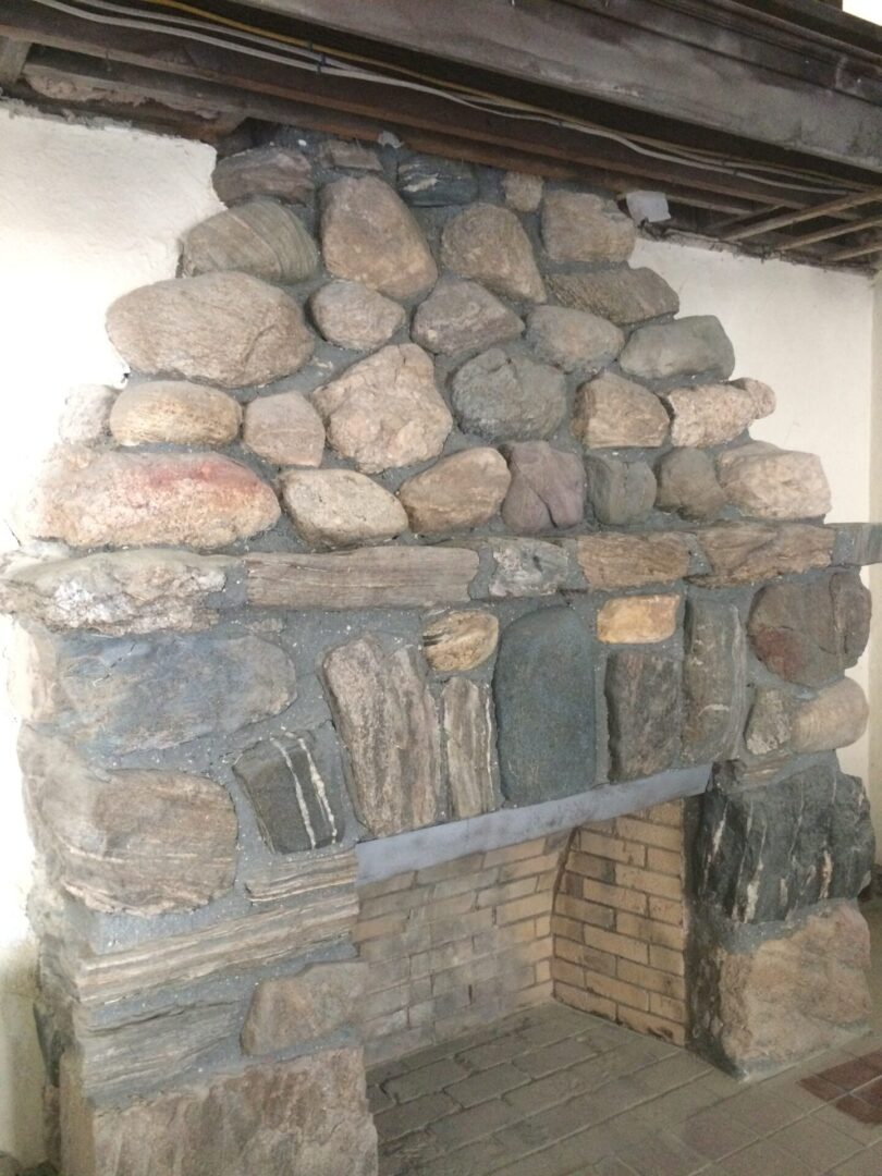 A fireplace with many rocks on the wall